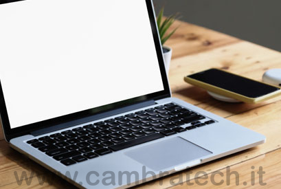 Immagine rappresentativa della categoria informatica e telefonia per disabili visivi in cui si vedono, adagiati su una scrivania, un notebook aperto e di fianco uno smartphone